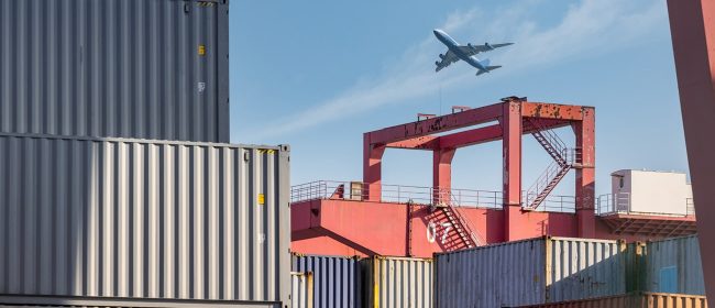 container-yard-closeup-with-airplane-in-sky-2023-11-27-04-50-06-utc.jpg